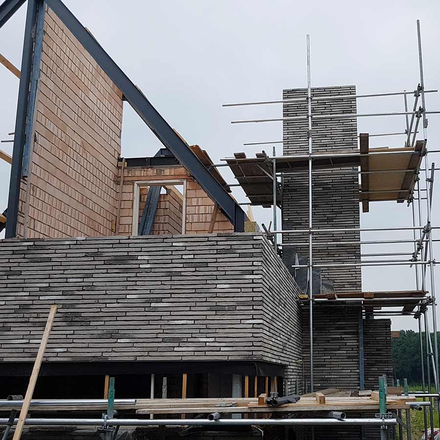 Schoorsteen in de steigers van een nieuwe woning in Nuland